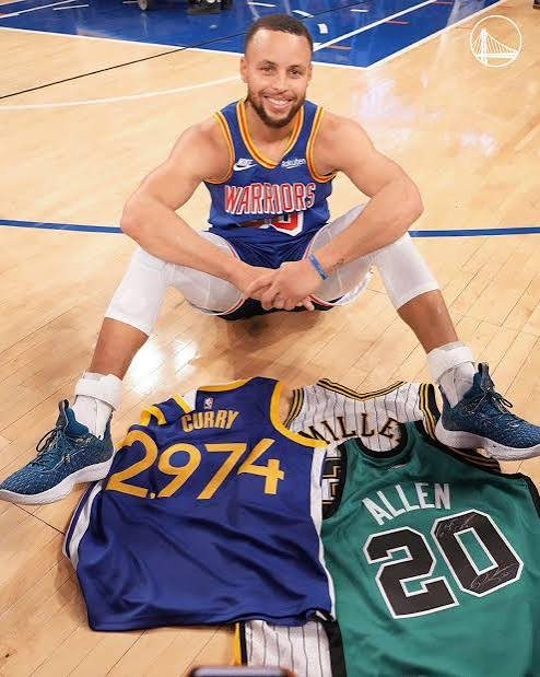 Curry sitting on court behind his 2,974 jersey and Ray Allen's No. 20 jersey