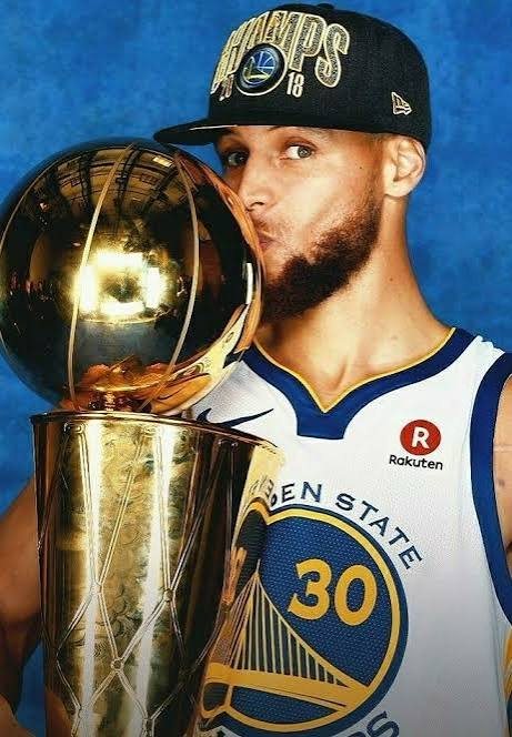 Curry kissing the NBA championship trophy