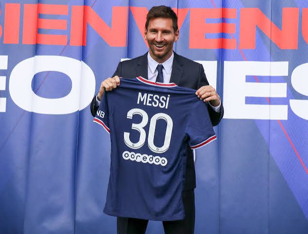 Messi holding up his PSG No. 30 shirt